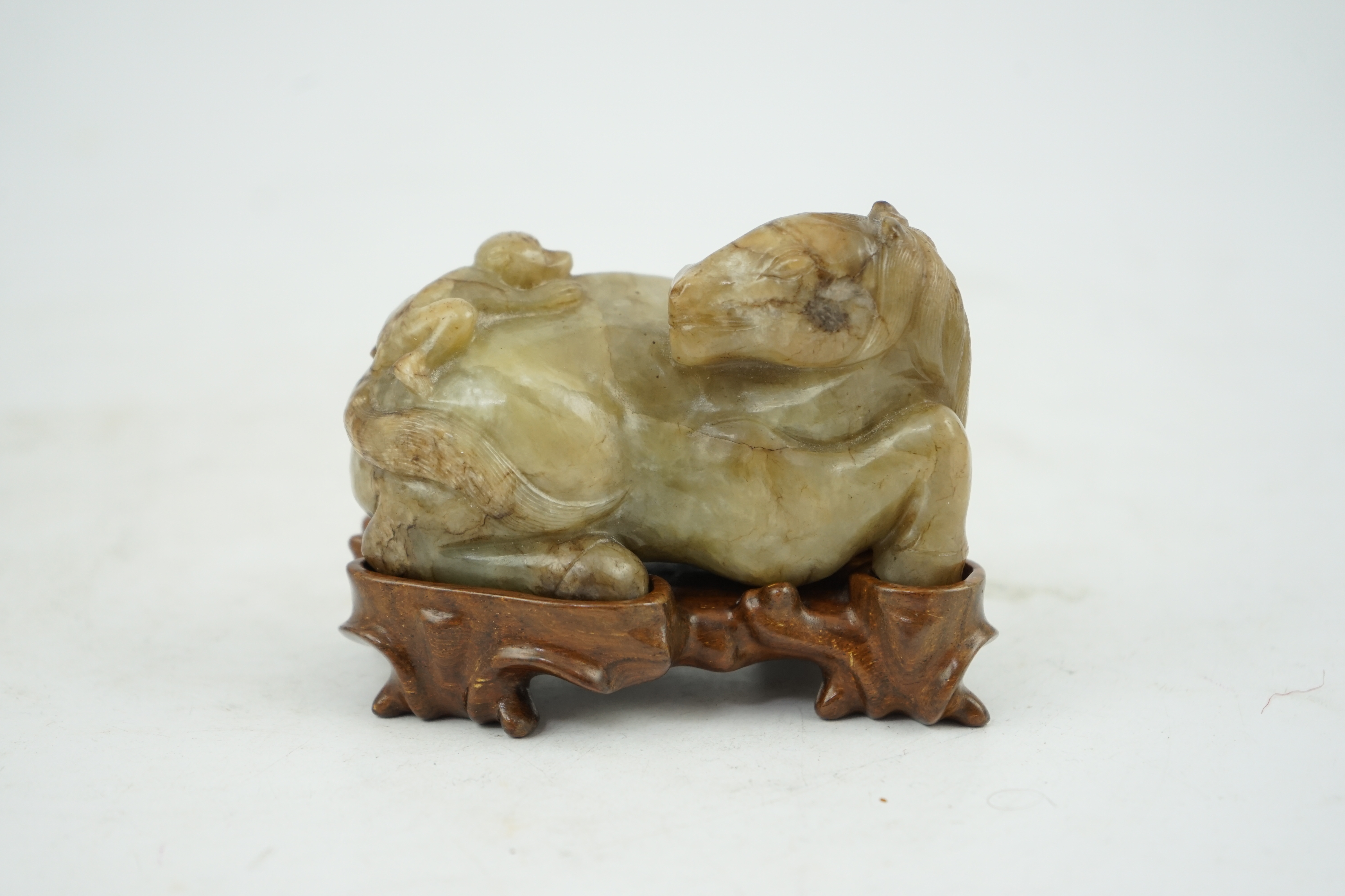 A Chinese celadon and mottled brown jade figure of a monkey climbing on a recumbent horse, Ming dynasty, 16th-17th century